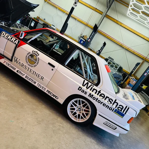 BMW M3 E30 DTM im Warsteiner-Design frontal in der Werkstatt, Haube geschlossen