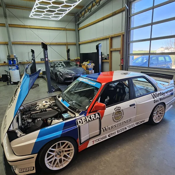 Offener Motorraum des BMW M3 E30 DTM mit Reihenvierzylinder und DEKRA-Aufkleber