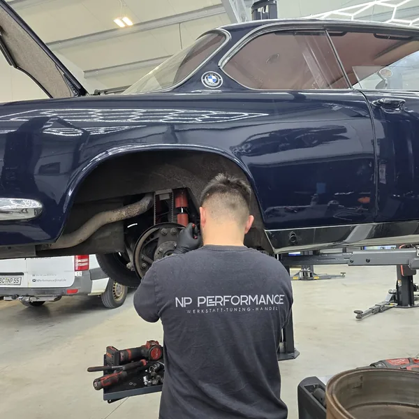 Mechaniker im NP-Performance-Shirt arbeitet an der Hinterachse eines BMW E9